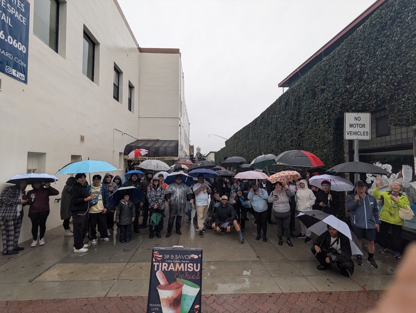 Trainers raiding together under umbrellas in the rain